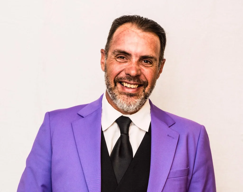 Promotional headshot of Derek Young Ward 10 Candidate, wearing a purple suit and smiling for his 2026 Sudbury municipal election campaign.